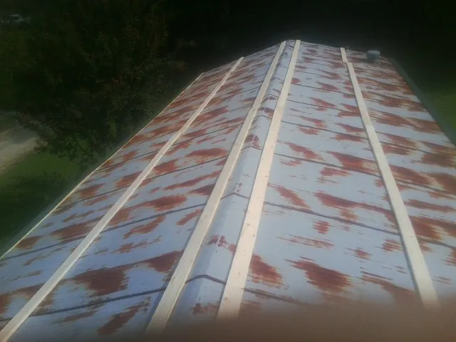 Rusted metal roof panels with new wood purlins before replacement — Storm Damage Roof Repair in Emporia by Roofing Brothers